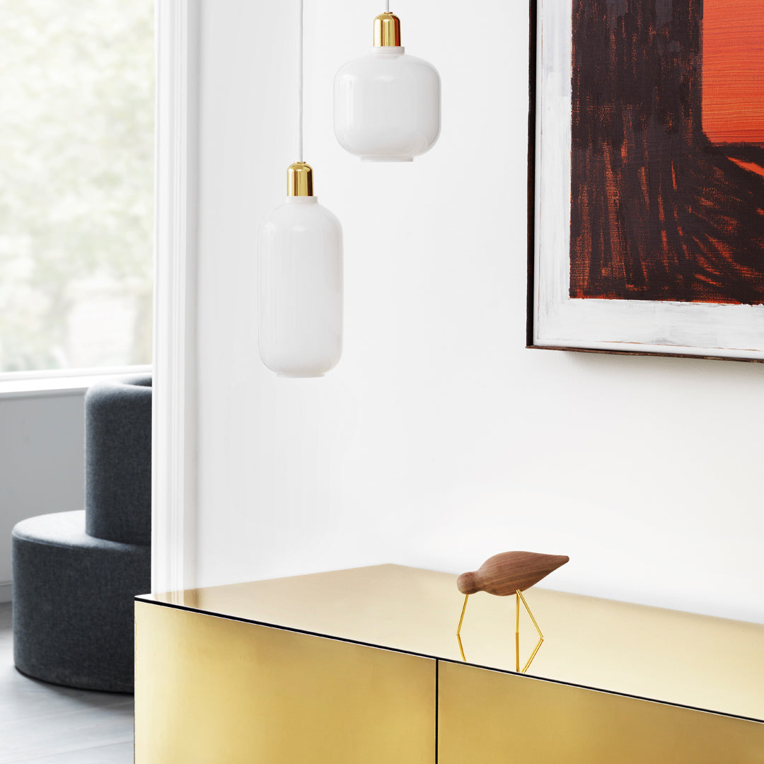 Gold accents with white and earthy tones; modern art piece with bold orange against neutral backdrop.