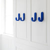 Bright blue wall hooks against a clean, white backdrop, featuring a sleek, modern design.