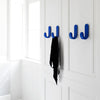 Blue hooks on a white wall, featuring smooth, curved designs; sleek and modern aesthetic.