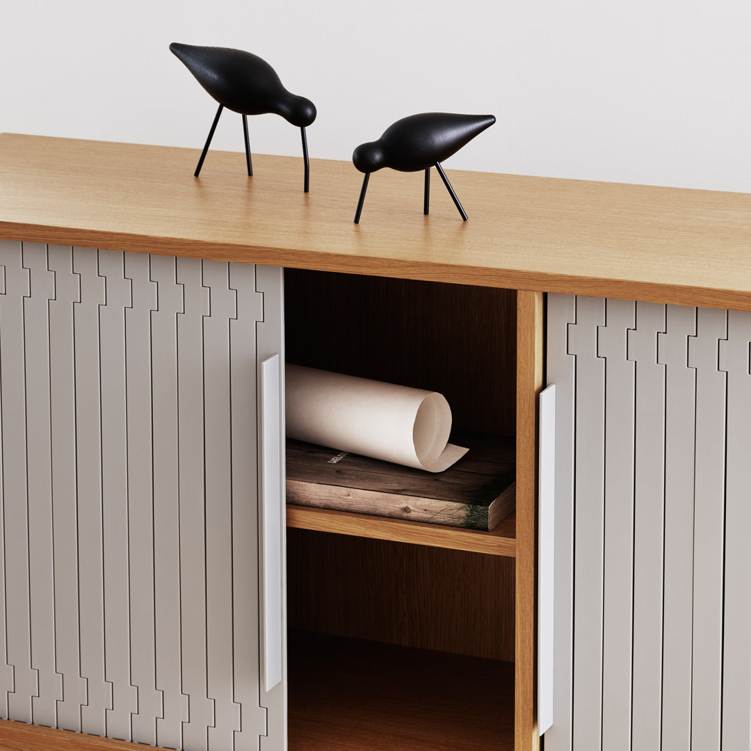 Gray vertical striped cabinet with a light wood top and black decorative birds. Elegant and modern design.