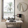 Stylish bathroom with a textured stone sink, black bowl, and soft, neutral-toned walls; modern minimalism meets nature.