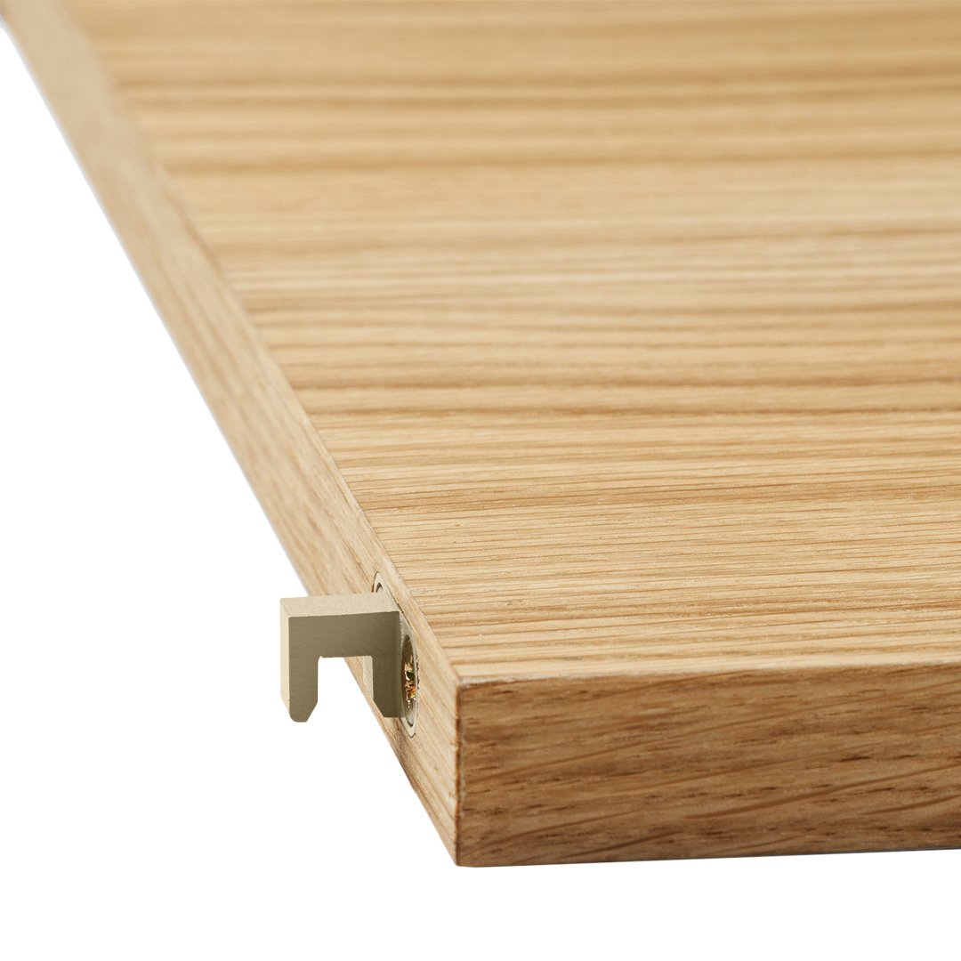 Light oak wood grain with subtle linear patterns and a hint of gold metal accent in the corner.