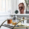 Elegant glassware and a ceramic statue with earthy tones, featuring clear and smoky textures. Modern tabletop decor.