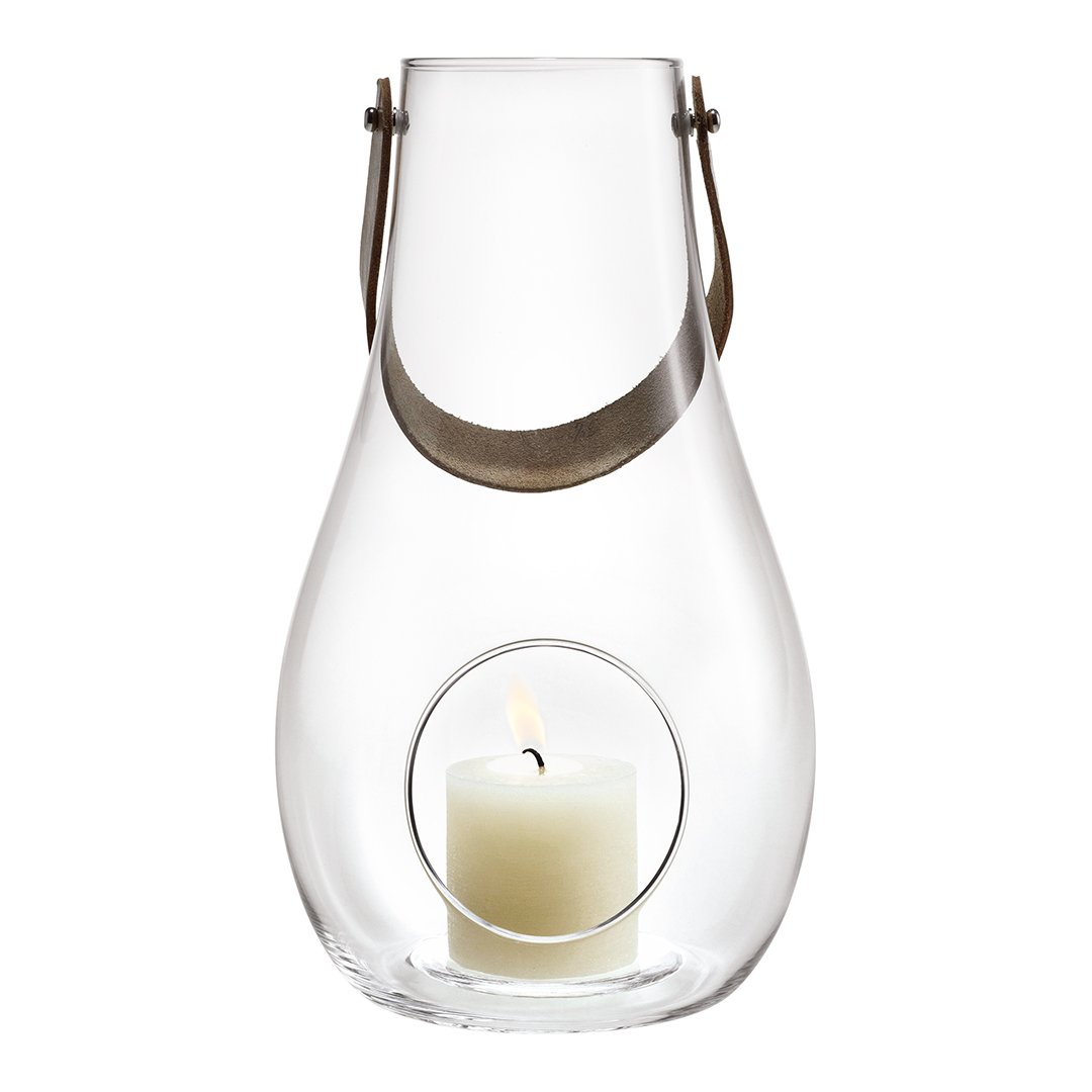 Clear glass lantern with a smooth, teardrop shape and a minimalist design. Features a neutral candle inside.