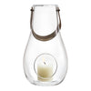 Clear glass lantern with a light gray accent strap, featuring a round cutout showcasing a white candle inside.