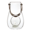 Clear glass lantern with a round cutout and light brown handle. Simple, modern design complements any decor.