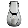 Clear glass lantern with elegant black accents and a circular opening, showcasing a white candle inside.