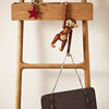 Wooden ladder with a red star and a playful brown monkey hanging, showcasing a gray bag with silver chains.