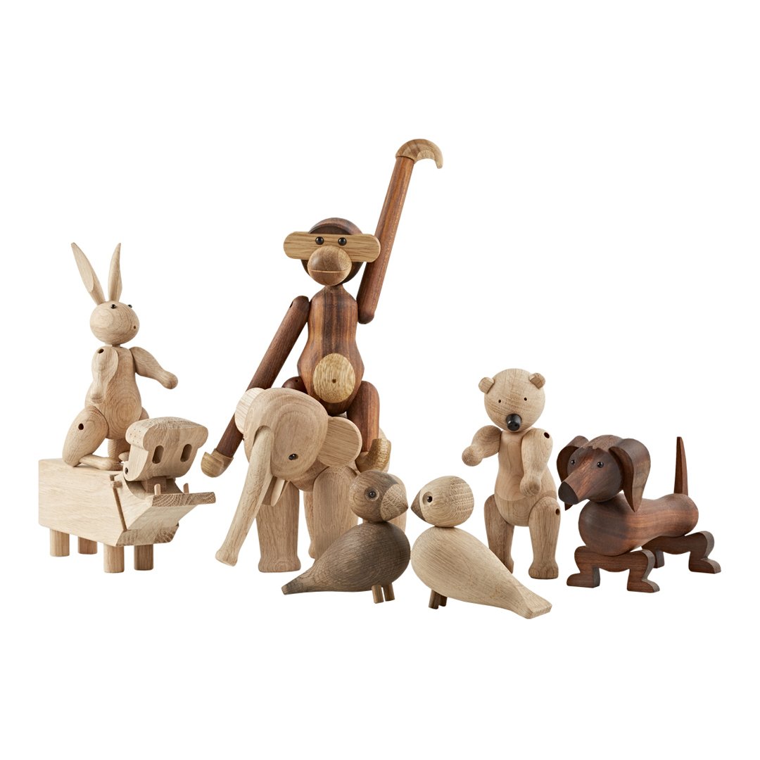 Wooden animal figurines in natural hues with a mix of light and dark tones. Simple, rustic design with minimal patterns.