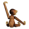 Wooden monkey figurine in natural brown tones with lighter accents; smooth, curved shapes and jointed limbs.