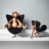 "Two playful wooden monkey figurines in black chairs, showcasing natural wood tones and unique detailing."