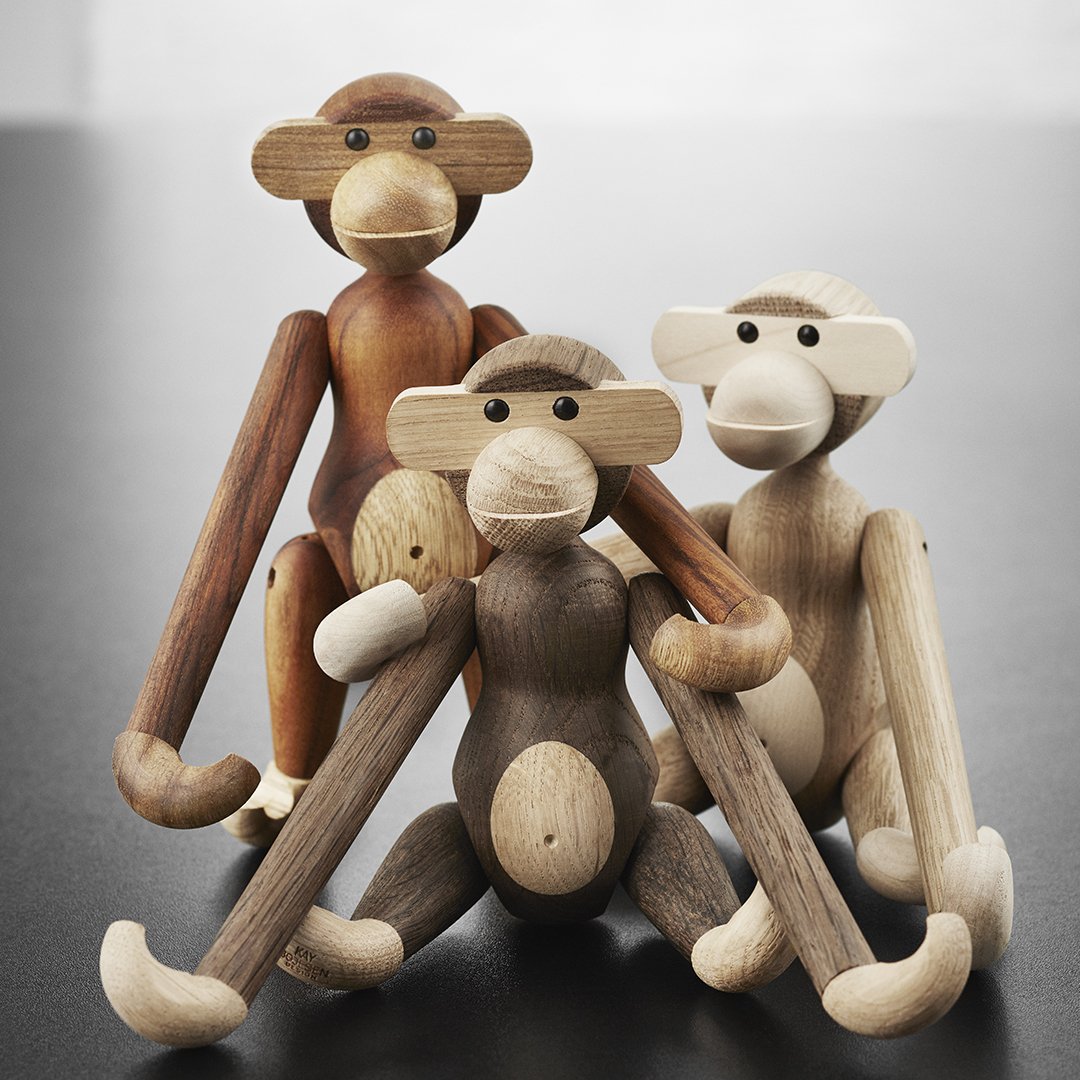 Wooden monkey figurines in natural tones of brown, beige, and cream with smooth finishes and playful designs.