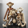 Wooden monkey figurines in natural tones of brown, beige, and cream with smooth finishes and playful designs.