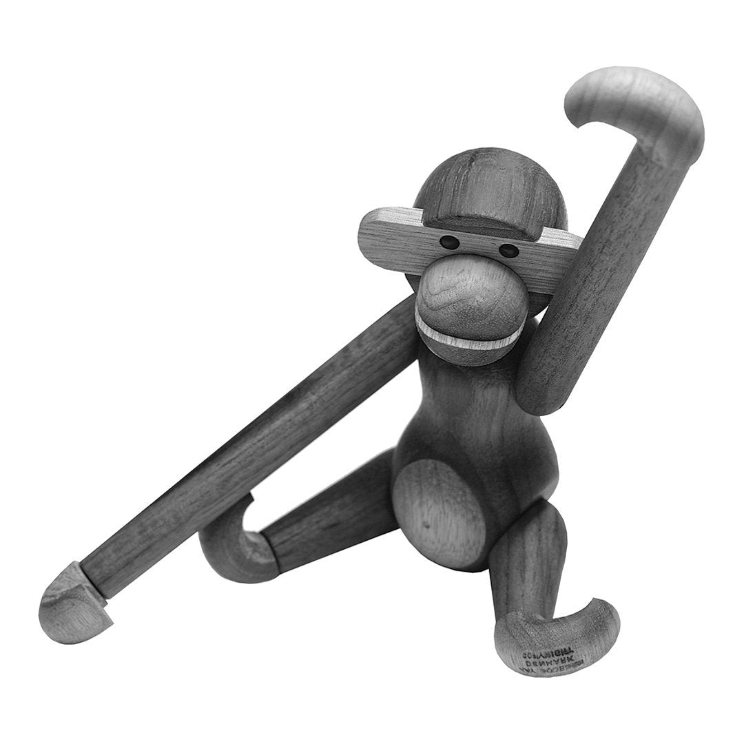 Wooden monkey figurine in a natural wood finish, showcasing smooth curves and playful pose against a monochrome background.