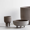 Set of three modern, ribbed ceramic pots in muted gray tones, featuring varying sizes and shapes.