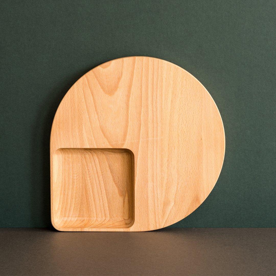 Natural wood serving plate with round and square shapes, showcasing a smooth grain and warm beige tones.